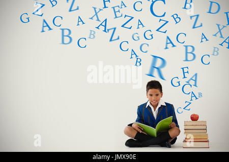 letters against schoolboy studying against white background Stock Photo