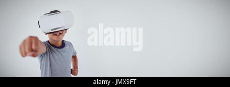 Schoolboy using virtual reality headset against white background Stock Photo