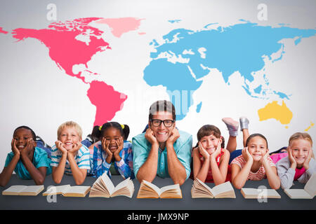 Portrait of teacher lying down with students against grey background Stock Photo