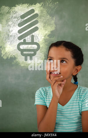 Digital composite image of light bulb on green spray paint against thoughtful young girl Stock Photo