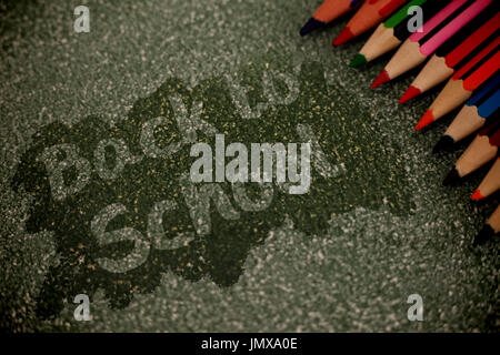 Back to school text on pink splash against multi colored pencils arranged Stock Photo