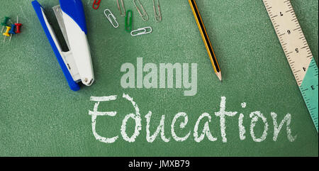 Education text against white background against high angle view of stapler and ruler on table Stock Photo