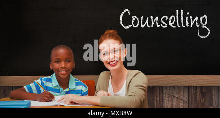 Happy pupil and teacher against blackboard on wooden wall Stock Photo