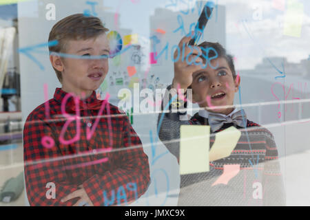 Kids as business executives discussing over whiteboard in office Stock Photo