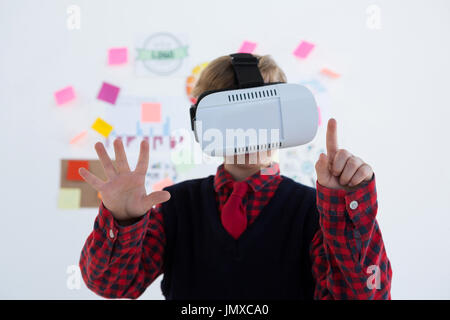 Boy as business executive using virtual reality headset in office Stock Photo