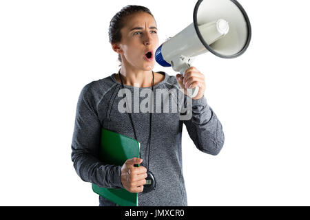 Female rugby coach announcing on megaphone while standing against white background Stock Photo