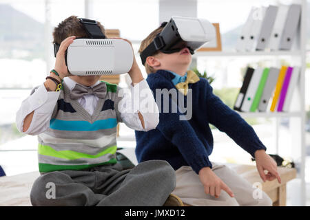 Kids as business executives using virtual reality headset in office Stock Photo