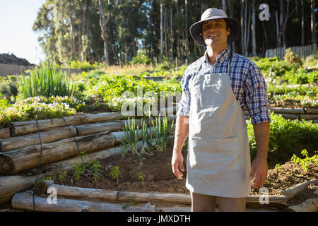 Portrait of smiling farmer standing in vineyard Stock Photo