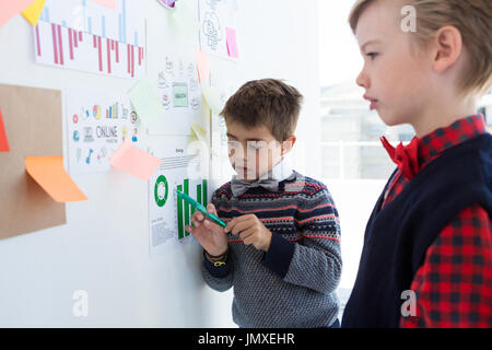 Kids as business executives discussing over whiteboard in office Stock Photo