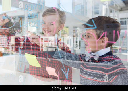 Kids as business executives discussing over whiteboard in office Stock Photo
