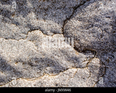 Detail of cracks in the weathered surface of granite rock on a seashore. Stock Photo