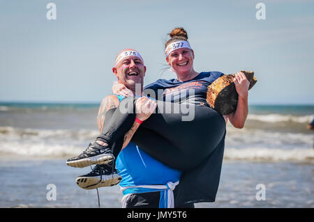 Log carry into the sea, unusual obstacle on obstacle course race. Stock Photo