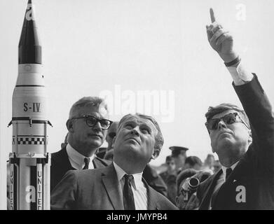 Marshall Space Flight Center (MSFC) Director, Doctor Wernher von Braun explains the Saturn Launch System to United States President John F. Kennedy at Cape Canaveral, Florida on November 16, 1963. National Aeronautics and Space Administration (NASA) Deputy Administrator Robert Seamans is to the left of von Braun..Credit: NASA via CNP