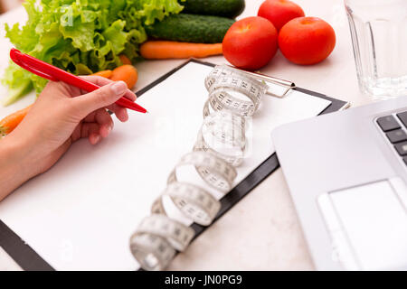 Healthy lifestyle concept. Writing weight loss plan with fresh vegetable diet and fitness Stock Photo