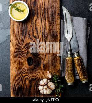 Cooking background concept. Vintage cutting board, cutlery and spices. Top view Stock Photo