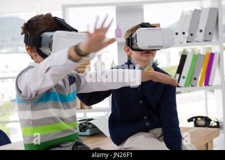 Kids as business executives using virtual reality headset in office Stock Photo