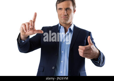 Businessman touching an invisible screen against white background Stock Photo