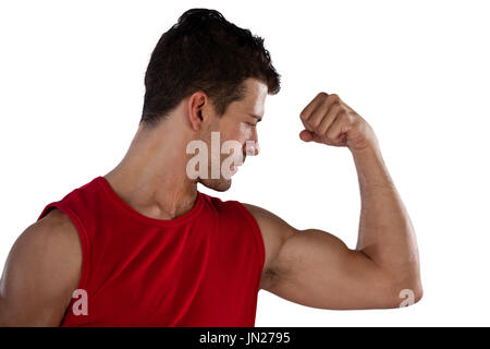 Close up of male athlete flexing muscles while standing against white background Stock Photo