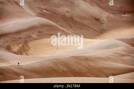 Man walking across the great sand dunes in Colorado, US Stock Photo