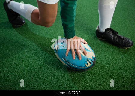 Low section of woman playing rugby on field Stock Photo