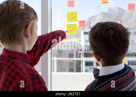 Kids as business executives discussing over whiteboard in office Stock Photo
