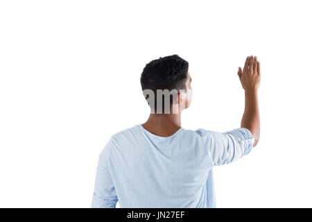 Man pretending to touch an invisible screen against white background	Rear view of man pretending to touch an invisible screen against white background Stock Photo