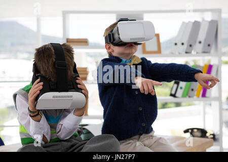 Kids as business executives using virtual reality headset in office Stock Photo