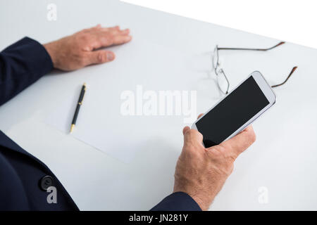 Mid-section of businessman sitting at table and using mobile phone Stock Photo