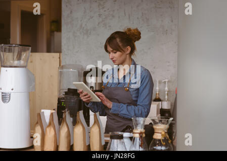 Waitress using digital tablet in cafÃƒÂ© Stock Photo