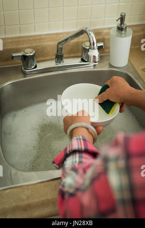 High angle view of woman washing dishes in kitchen Stock Photo