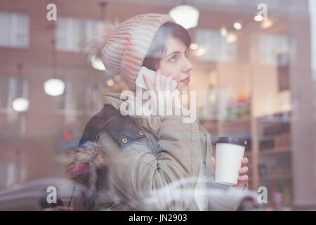 Young woman talking on mobile phone in store Stock Photo