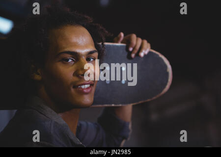 Portrait of man holding skateboard Stock Photo