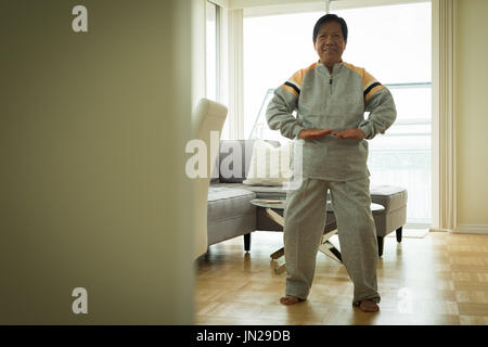 Portrait of senior woman exercising while standing home Stock Photo