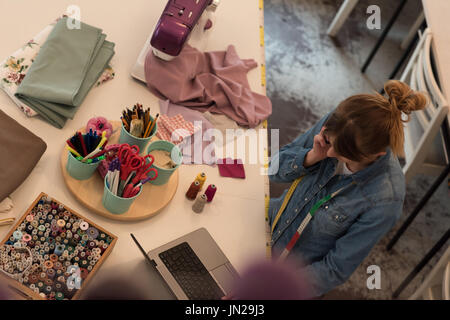 Female fashion designer working on laptop in the studio Stock Photo