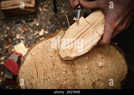 Close-up of carpenter carving wood with chisel in workshop Stock Photo