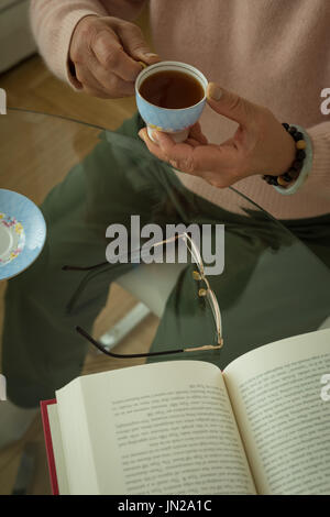 High angle view senior woman having tea while sitting at home Stock Photo
