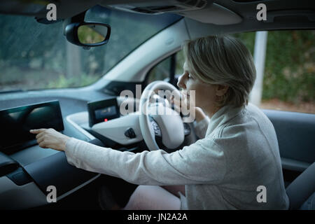 Side view of woman using digital tablet while driving car Stock Photo