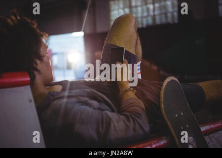Rear view of man using mobile phone in skateboard arena Stock Photo