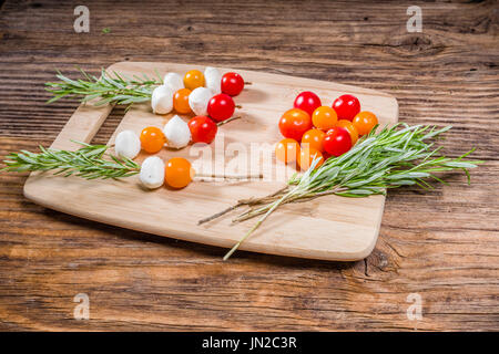 Tomatoes and cheese balls on rosemary skewers Stock Photo