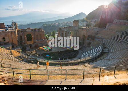 Taormina theater Sicily, view of tourists visiting the ancient Greek theatre (Teatro Greco) in Taormina at sunset, Sicily. Stock Photo