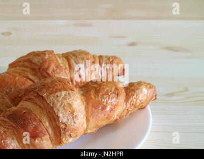 Closed up fresh baked whole wheat croissant pastries served on wooden table, with free space for text and design Stock Photo