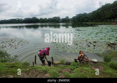 Women washing at the lotus pond at Shait Gumbad Mosque, Bagerhat, Bangladesh Stock Photo