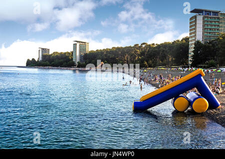 The beach on the Black sea coast in the evening. Calm sea and many tourists . Stock Photo