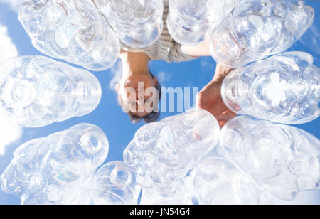 Woman recycling plastic water bottles high key looking up POV in New Zealand, NZ Stock Photo