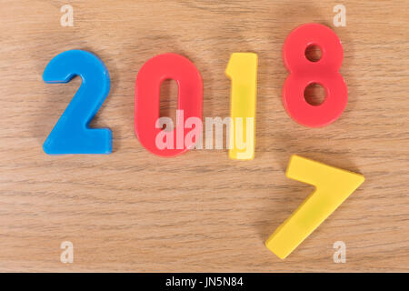 Colourful toy learning numbers on a plain timber background representing the year changing from 2017 to 2018. Stock Photo