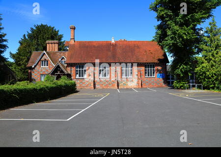 The old school building adjacent to the local church with an attached school masters house with the original bell still in place. Stock Photo