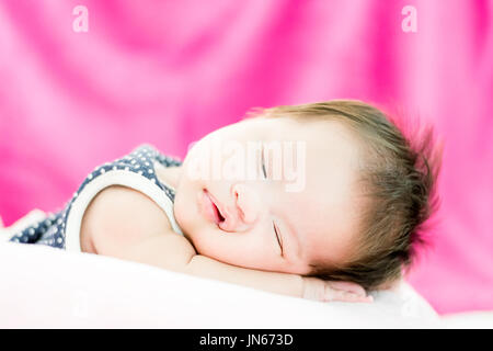 Portrait of a little adorable infant baby girl yawning before sleep on the bed indoors Stock Photo