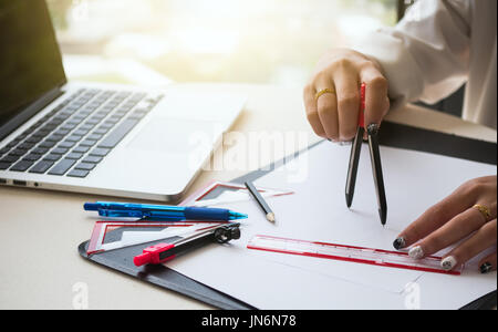 The female architects are using dividers and tools for idesign on the blueprints Stock Photo