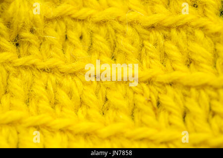 A beautiful closeup of a hand made crochet pattern of a colorful wool yarn. Soft and warm natural sheep wool. Pattern of wool. Stock Photo