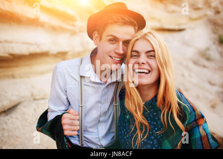 Handsome man and beautiful woman smiling into the camera in the middle of a sandy canyon. Stock Photo